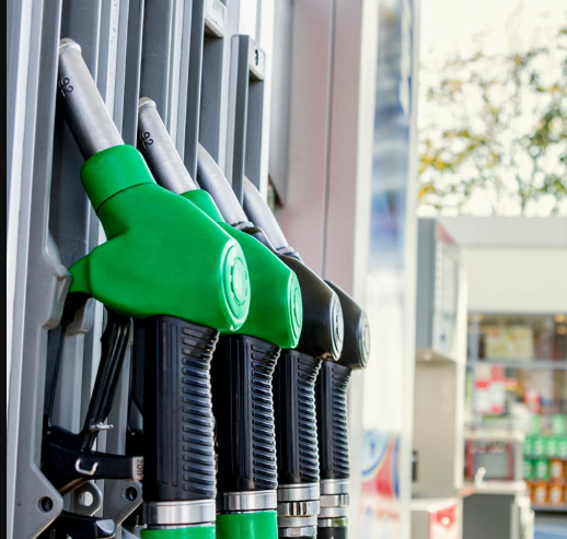 Green fuel pump nozzles at a gas station ready for refueling