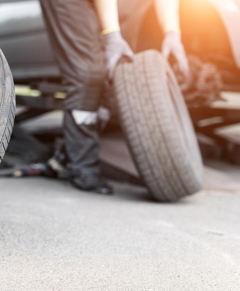 Roadside technician changing a vehicle tire on-site